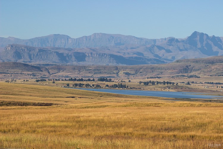 dry grass field and lake infront of blue looking Drakensberg Mountain-Durban-day-Tours